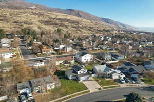 Aerial view of property and surrounding area featuring nearby suburban area and a mountain backdrop