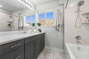 Ensuite bahtroom with  with vanity, bathing tub / shower combination, light marble finish flooring, and a mountain view