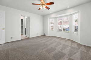 Unfurnished bedroom featuring ensuite and  walk in closet, new carpet flooring, ceiling fan, recessed lighting, and a textured ceiling