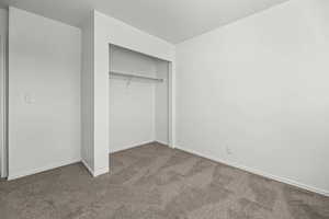 Unfurnished bedroom featuring a closet and carpet floors