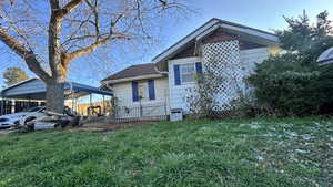 View of property exterior with a yard and a carport