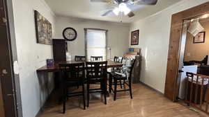 Dining room with ornamental molding, light wood finished floors, and ceiling fan