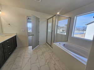Bathroom with light marble finish floors, vanity, a shower stall, and a bath