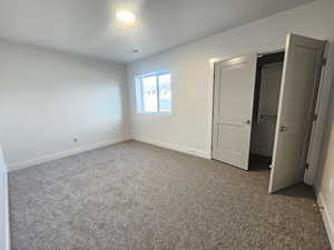 Unfurnished bedroom featuring carpet floors and a walk in closet
