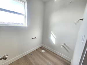 Laundry room featuring wood finished floors and plenty of natural light