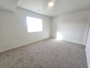 Empty room featuring carpet flooring and baseboards