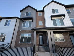 View of front of property featuring board and batten siding, covered porch, and brick siding