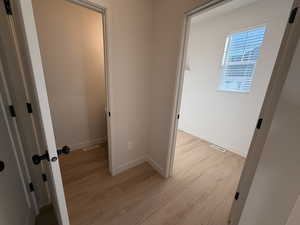 Corridor with light wood finished floors and baseboards