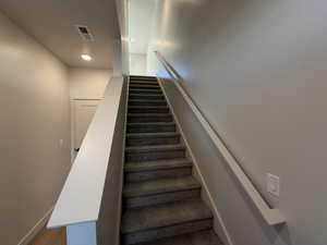 Staircase featuring recessed lighting and baseboards