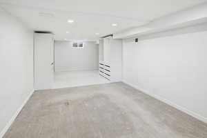 Basement with light carpet and recessed lighting