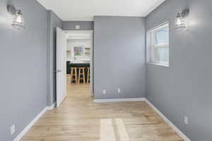 Hallway featuring light wood finished floors and baseboards