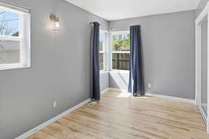 Unfurnished room with light wood finished floors and baseboards