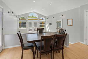 Dining area with french doors, light wood-style floors, and recessed lighting