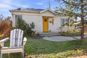 View of front facade featuring brick siding, a shingled roof, and a front yard