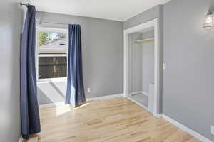 Unfurnished bedroom with light wood-style floors and baseboards