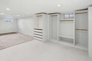 Walk in closet featuring light colored carpet