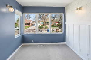 Empty room featuring light colored carpet and healthy amount of natural light