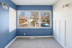 Carpeted spare room with baseboards and a residential view