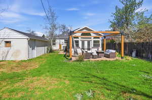 Fenced yard with outdoor lounge area, an outbuilding, french doors, and a patio area