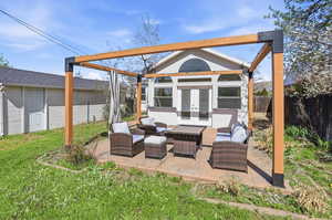 Fenced backyard with outdoor lounge area, an outbuilding, french doors, and a patio area