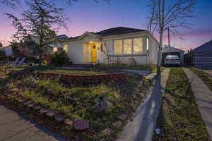 View of front facade with an outdoor structure, brick siding, and a detached garage