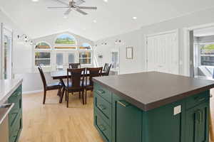 Kitchen with green cabinetry, dark countertops, light wood-type flooring, french doors, and recessed lighting