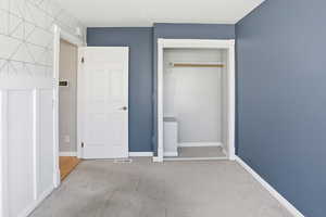 Unfurnished bedroom featuring light carpet and a closet