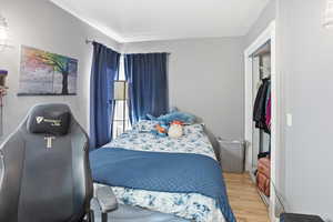 Bedroom with light wood-type flooring and a closet