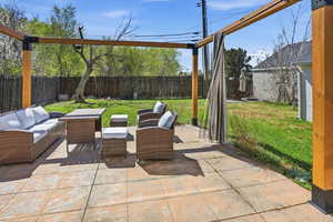 Fenced backyard featuring an outdoor lounge area and a patio
