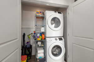 Washroom featuring estacked washer and dryer and wood finished floors