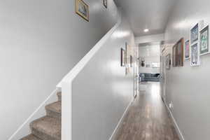Hallway with stairway and wood finished floors