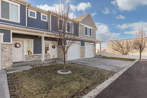 Traditional-style home featuring stone siding, driveway, and a garage
