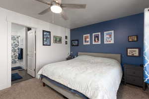 Carpeted bedroom with a ceiling fan