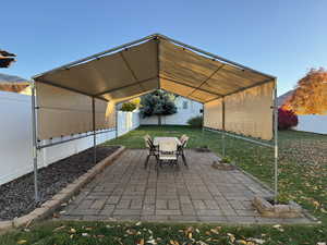 Fenced backyard featuring outdoor dining area, a patio, and a mountain view