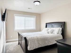 Bedroom featuring light colored carpet and baseboards