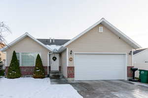 View of front of house featuring brick siding, concrete driveway, and a garage