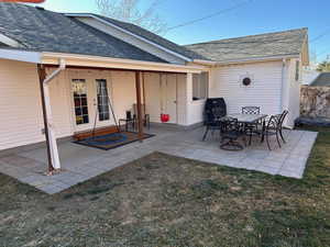 Rear view of house featuring french doors, a patio area, and roof with shingles