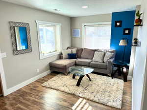 Living room area, with updated wood flooring, recessed lighting, updated finish work, and plenty of natural light.