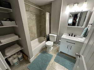 Bathroom with vanity, shower / bath combo, and light tile patterned floors