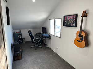 Carpeted office featuring vaulted ceiling