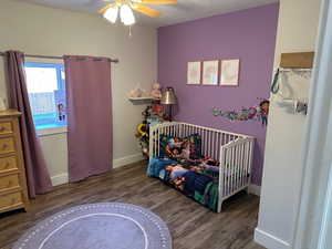 Bedroom featuring dark wood-style flooring, a textured ceiling, and ceiling fan