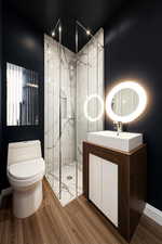 Full bathroom featuring vanity, a marble finish shower, and wood finished floors