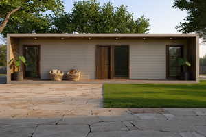 View of front facade with a patio and a front lawn