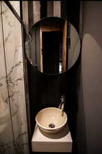 Bathroom with a marble finish shower and vanity