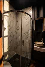Bathroom with vanity and a marble finish shower