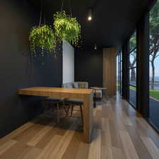 Dining room with light wood finished floors, plenty of natural light, a water view, and expansive windows
