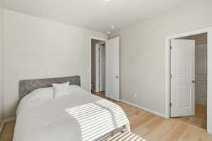 Bedroom with light wood finished floors and baseboards