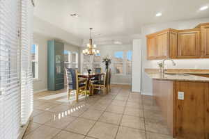 Dining space featuring light tile patterned floors and a chandelier