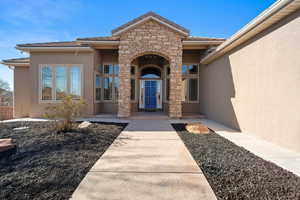 Entrance to property with stone siding and stucco siding