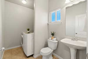 Bathroom featuring washer and dryer and light tile patterned floors